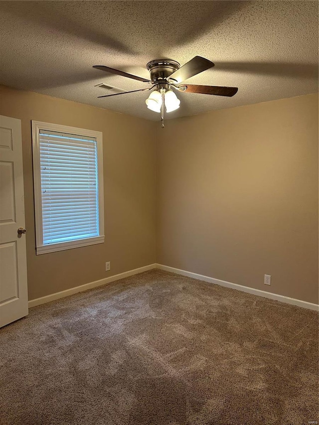 empty room featuring carpet flooring, ceiling fan, and a textured ceiling