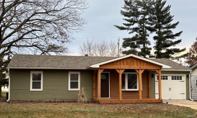 view of front of property featuring a garage and a front lawn