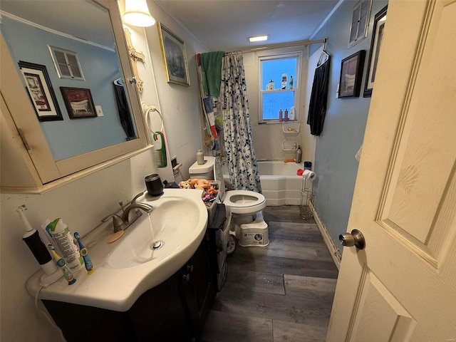 full bathroom with shower / bath combo, hardwood / wood-style floors, toilet, vanity, and ornamental molding