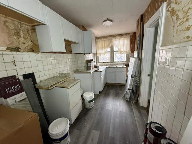 kitchen featuring dark hardwood / wood-style floors, white cabinetry, and tasteful backsplash