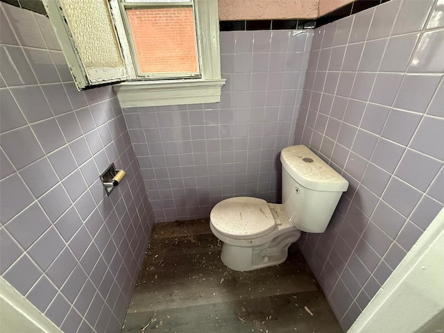 bathroom with tile walls and toilet