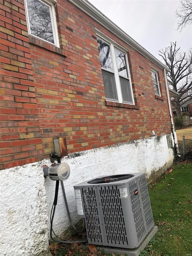 view of side of property featuring central air condition unit and a yard