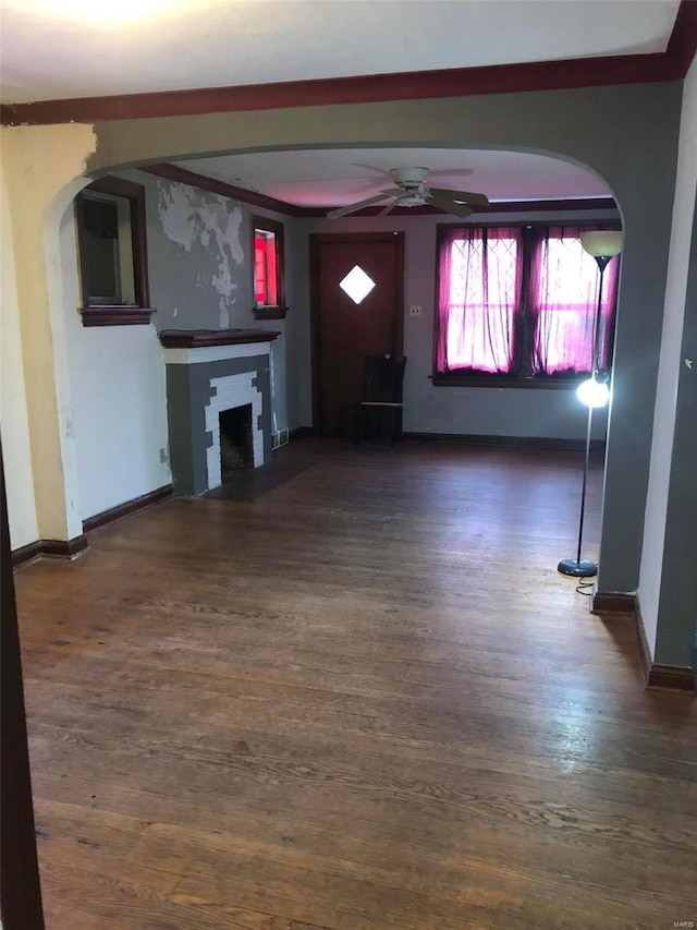 unfurnished living room featuring ceiling fan, dark hardwood / wood-style flooring, and a brick fireplace