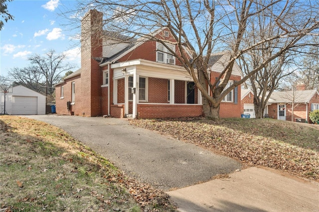 view of side of property featuring a porch, a garage, and an outdoor structure