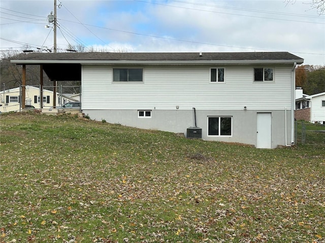 rear view of house featuring a lawn and central AC