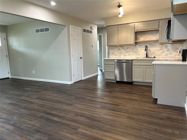 kitchen featuring dishwasher, sink, dark hardwood / wood-style flooring, gray cabinets, and decorative backsplash