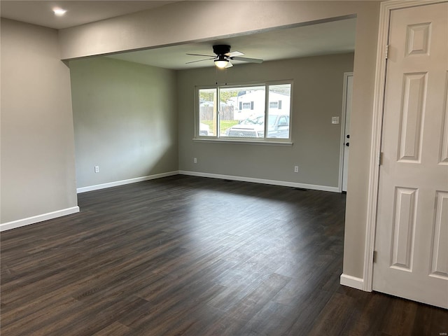 empty room with ceiling fan and dark hardwood / wood-style flooring