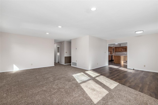 unfurnished living room with dark colored carpet