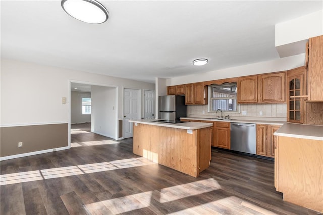 kitchen with backsplash, stainless steel appliances, sink, dark hardwood / wood-style floors, and a kitchen island