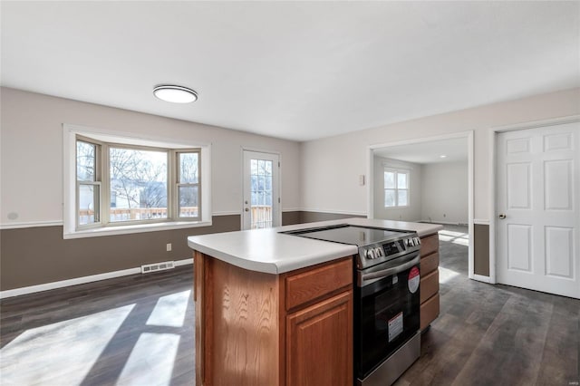 kitchen featuring electric range, a center island, and dark hardwood / wood-style floors