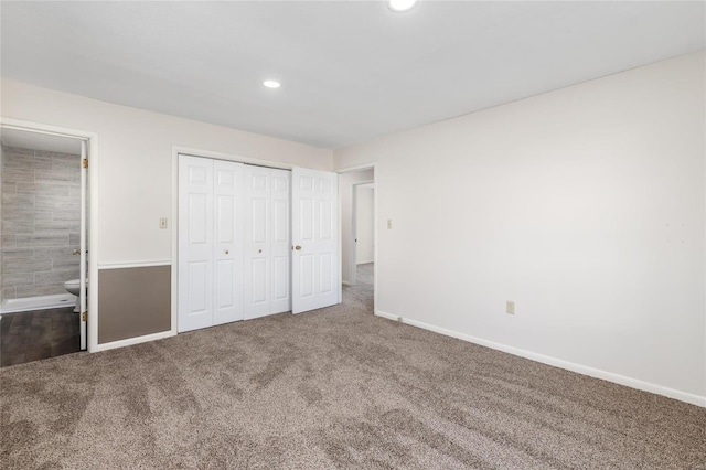 unfurnished bedroom featuring carpet flooring, ensuite bath, and a closet