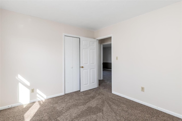 unfurnished bedroom featuring carpet flooring and a closet