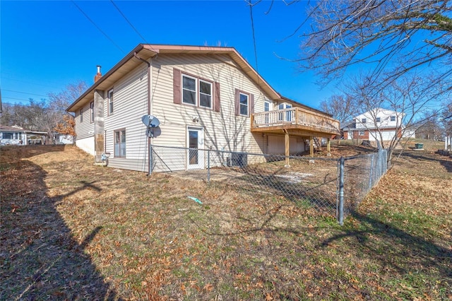 rear view of property featuring a lawn and a wooden deck