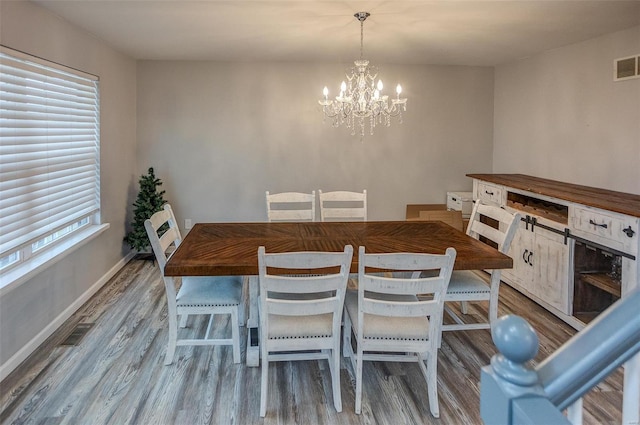 unfurnished dining area featuring light wood-type flooring and an inviting chandelier