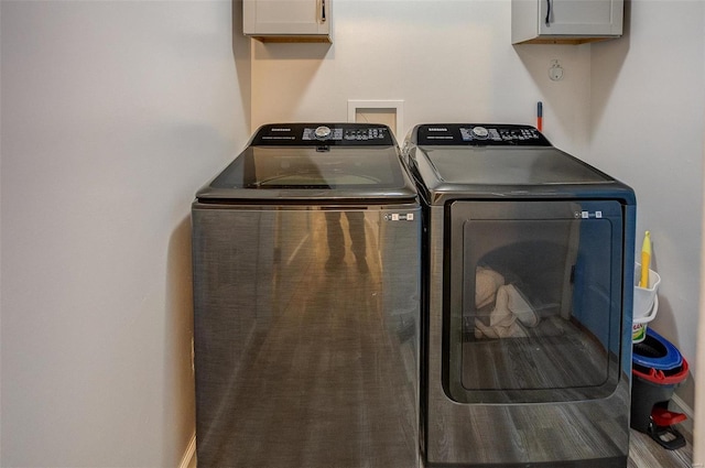 laundry area featuring washer and clothes dryer and cabinets