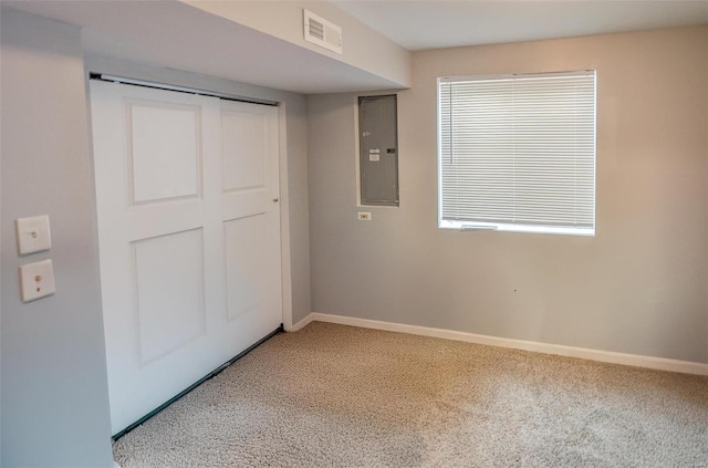 unfurnished bedroom featuring electric panel, a closet, and carpet floors