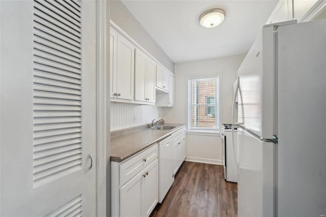 kitchen featuring dark wood-type flooring, sink, white cabinets, and white appliances