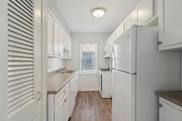 kitchen featuring dark hardwood / wood-style flooring, sink, white appliances, and white cabinetry