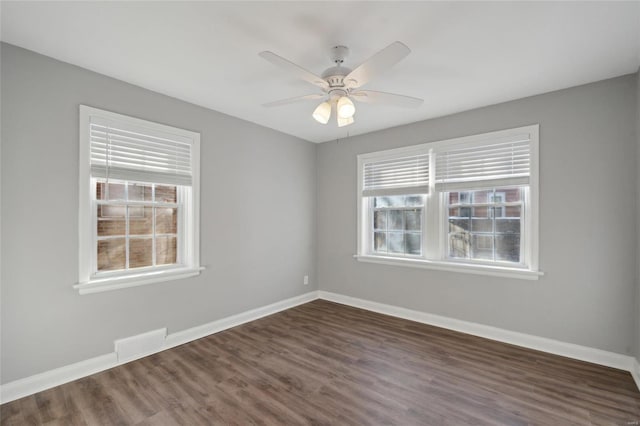 spare room with ceiling fan and dark wood-type flooring