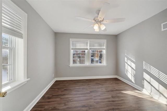 spare room with ceiling fan, dark wood-type flooring, and a wealth of natural light