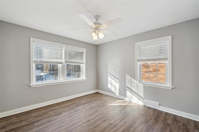 unfurnished room with ceiling fan and dark wood-type flooring