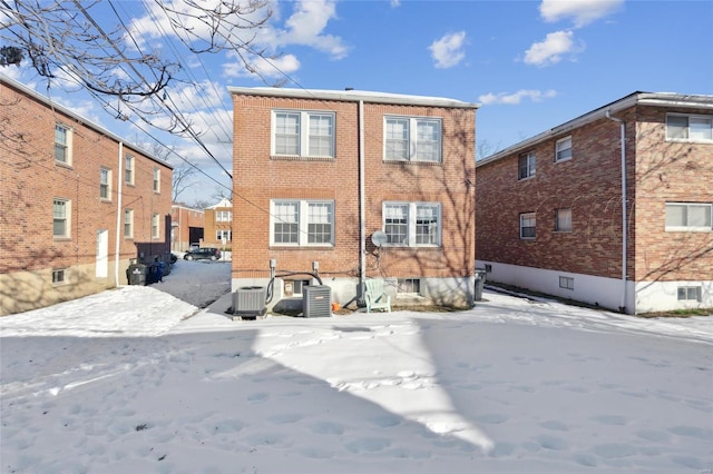 snow covered rear of property with central AC