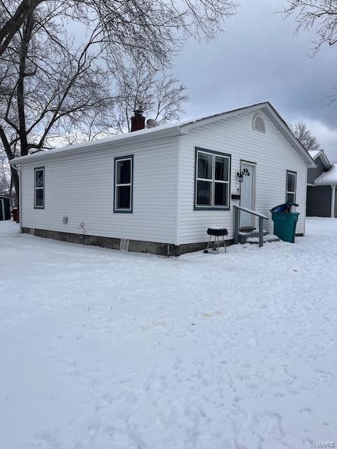 view of snow covered back of property