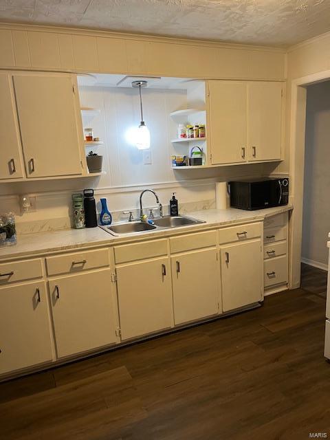 kitchen with dark hardwood / wood-style flooring, a textured ceiling, sink, decorative light fixtures, and white cabinetry