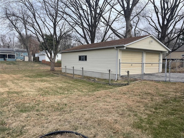 view of side of home with a lawn, a garage, and an outdoor structure