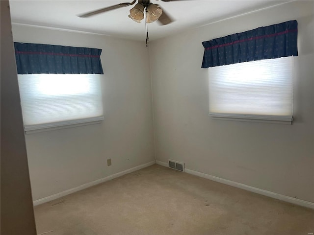 carpeted empty room featuring ceiling fan and a wealth of natural light