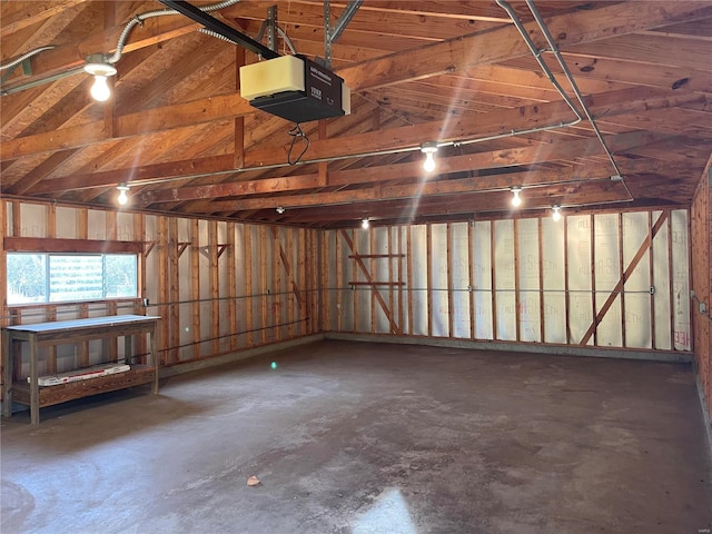 garage featuring a garage door opener and wooden walls