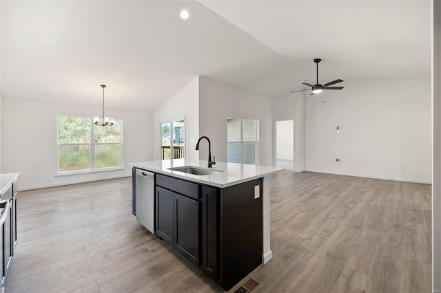 kitchen featuring vaulted ceiling, sink, dishwasher, hanging light fixtures, and an island with sink