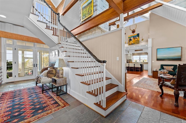 stairs with high vaulted ceiling, french doors, and wood finished floors