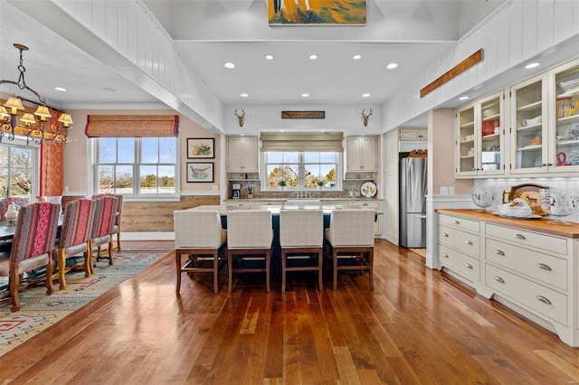 kitchen with a center island, wood-type flooring, a wealth of natural light, and freestanding refrigerator