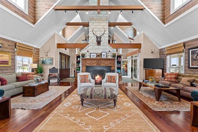 living area with high vaulted ceiling, wood-type flooring, a fireplace, and track lighting