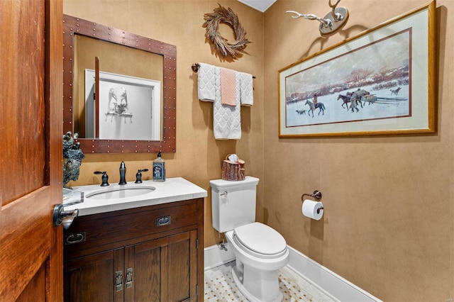 half bathroom featuring vanity, toilet, and baseboards