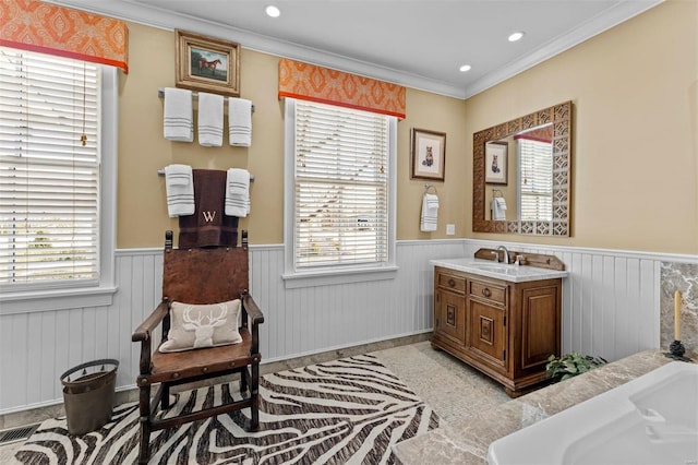 living area with visible vents, wainscoting, a wealth of natural light, and crown molding