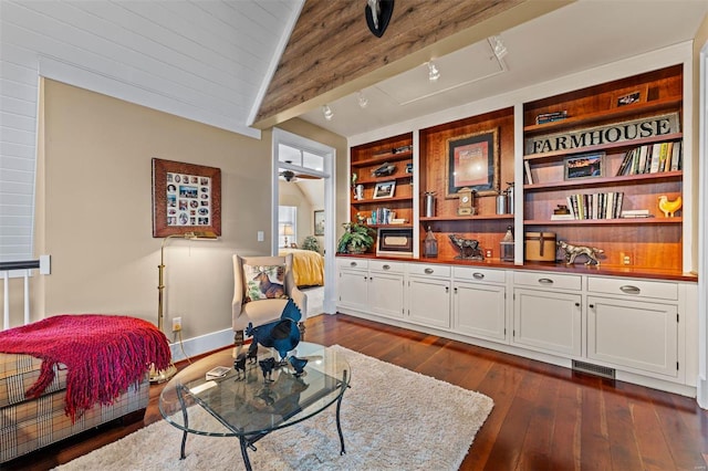 sitting room featuring lofted ceiling with beams, visible vents, baseboards, built in features, and dark wood-style floors