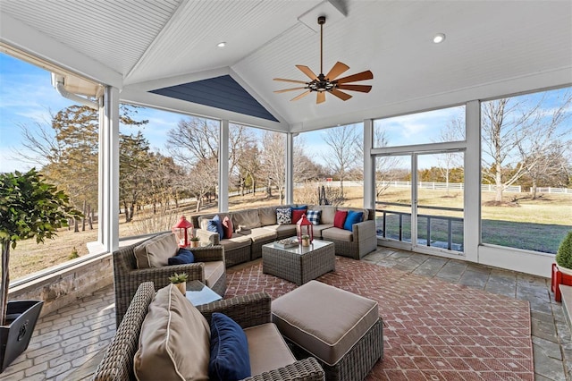 sunroom / solarium with lofted ceiling and a ceiling fan