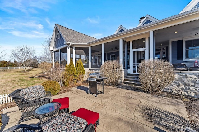 view of patio featuring a ceiling fan, a sunroom, fence, and grilling area