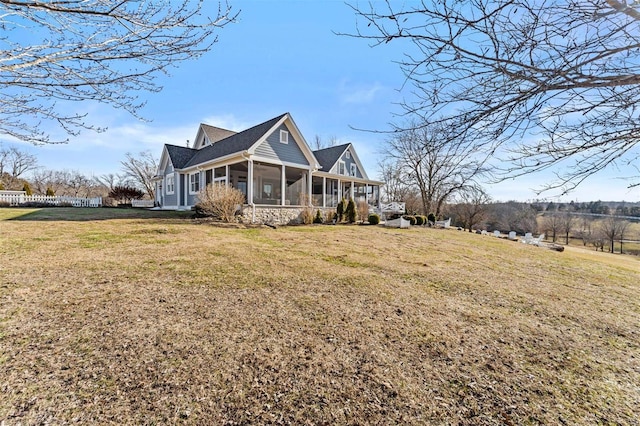 view of front of property featuring a sunroom and a front lawn