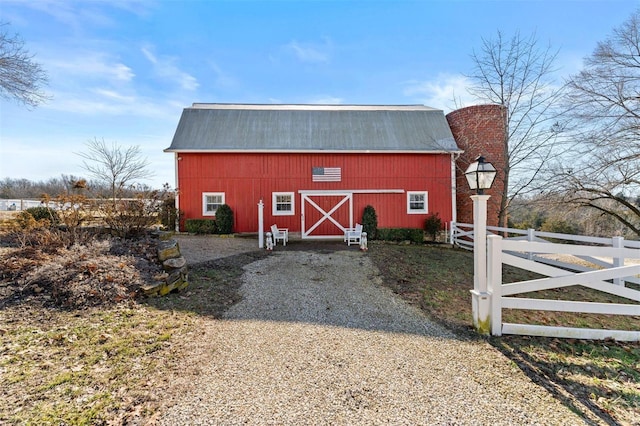 view of barn featuring fence