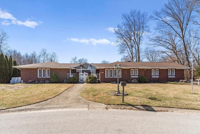 ranch-style house featuring a front yard, concrete driveway, and brick siding