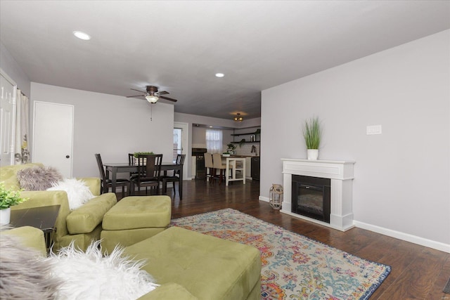 living room featuring ceiling fan and dark hardwood / wood-style floors