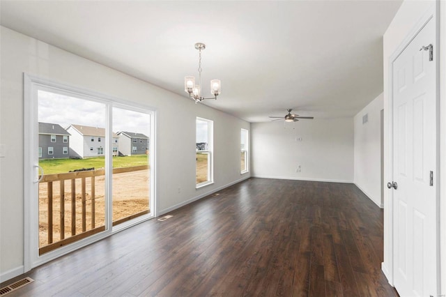 spare room with ceiling fan with notable chandelier and dark wood-type flooring