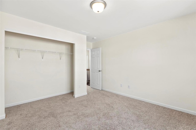 unfurnished bedroom with light carpet and a closet