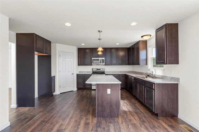 kitchen with sink, decorative light fixtures, a kitchen island, dark hardwood / wood-style flooring, and stainless steel appliances