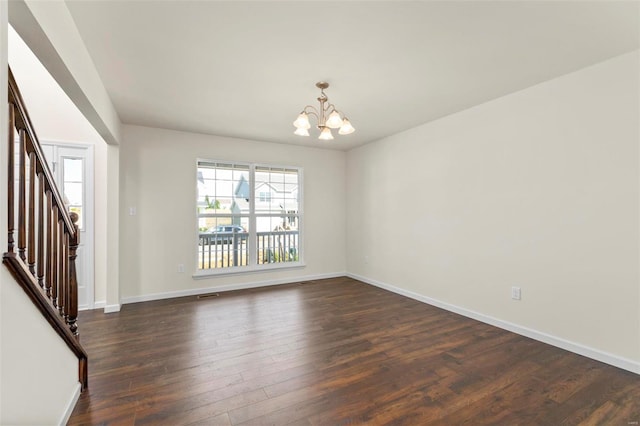 unfurnished room featuring a chandelier and dark hardwood / wood-style floors