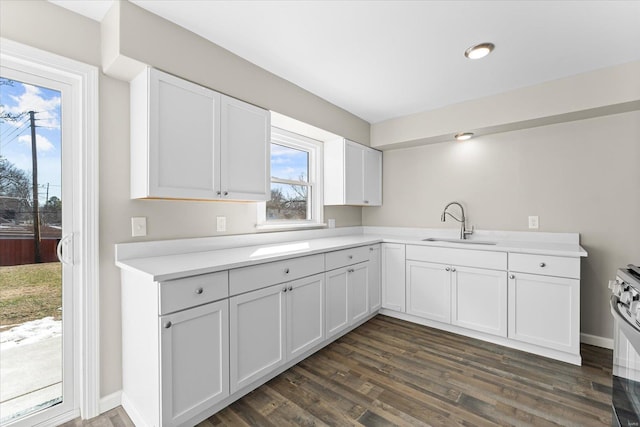 kitchen featuring dark hardwood / wood-style flooring, sink, white cabinets, and range