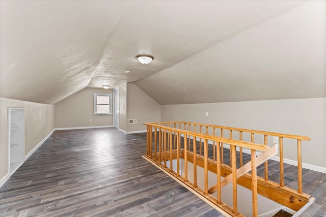 additional living space featuring lofted ceiling and dark wood-type flooring